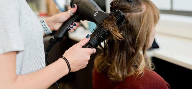 woman having hair cut and dried.