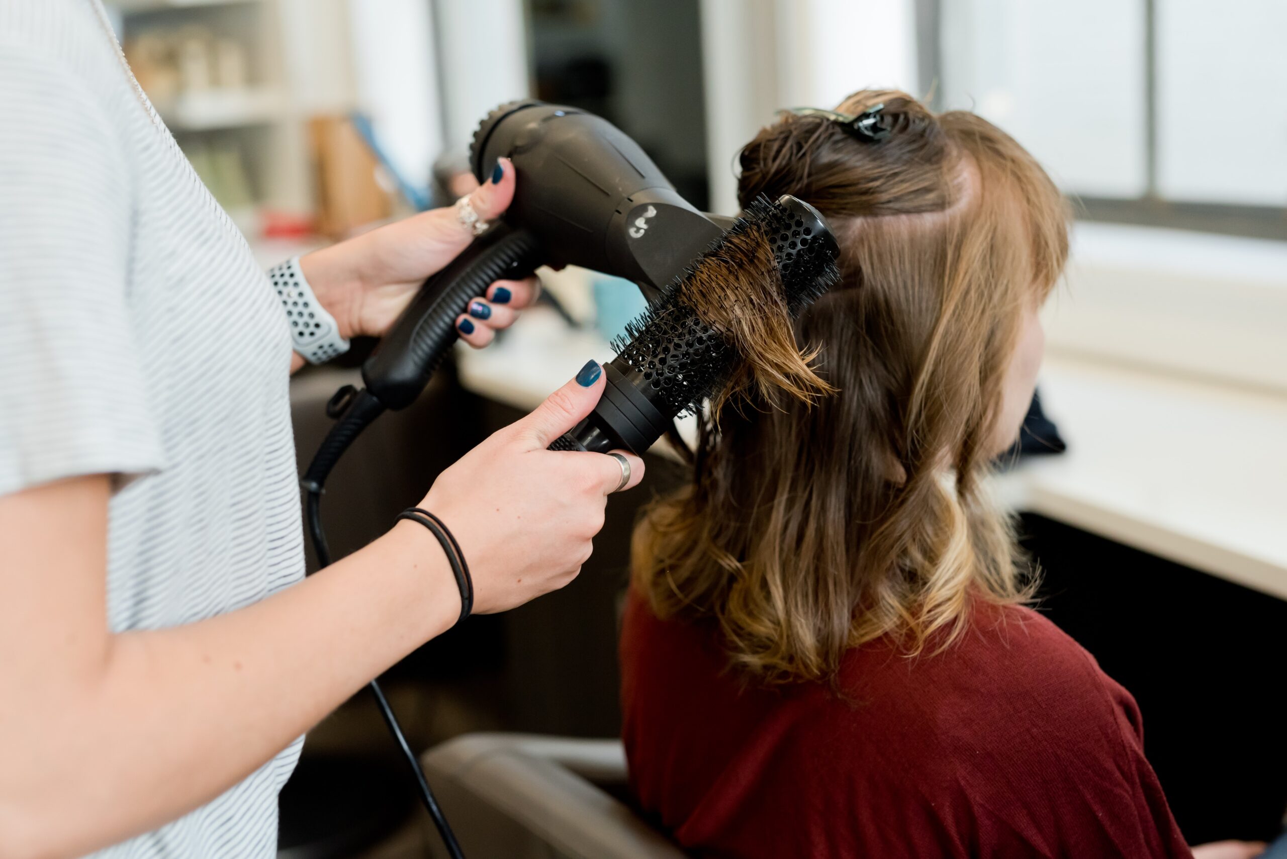 woman having hair cut and dried.