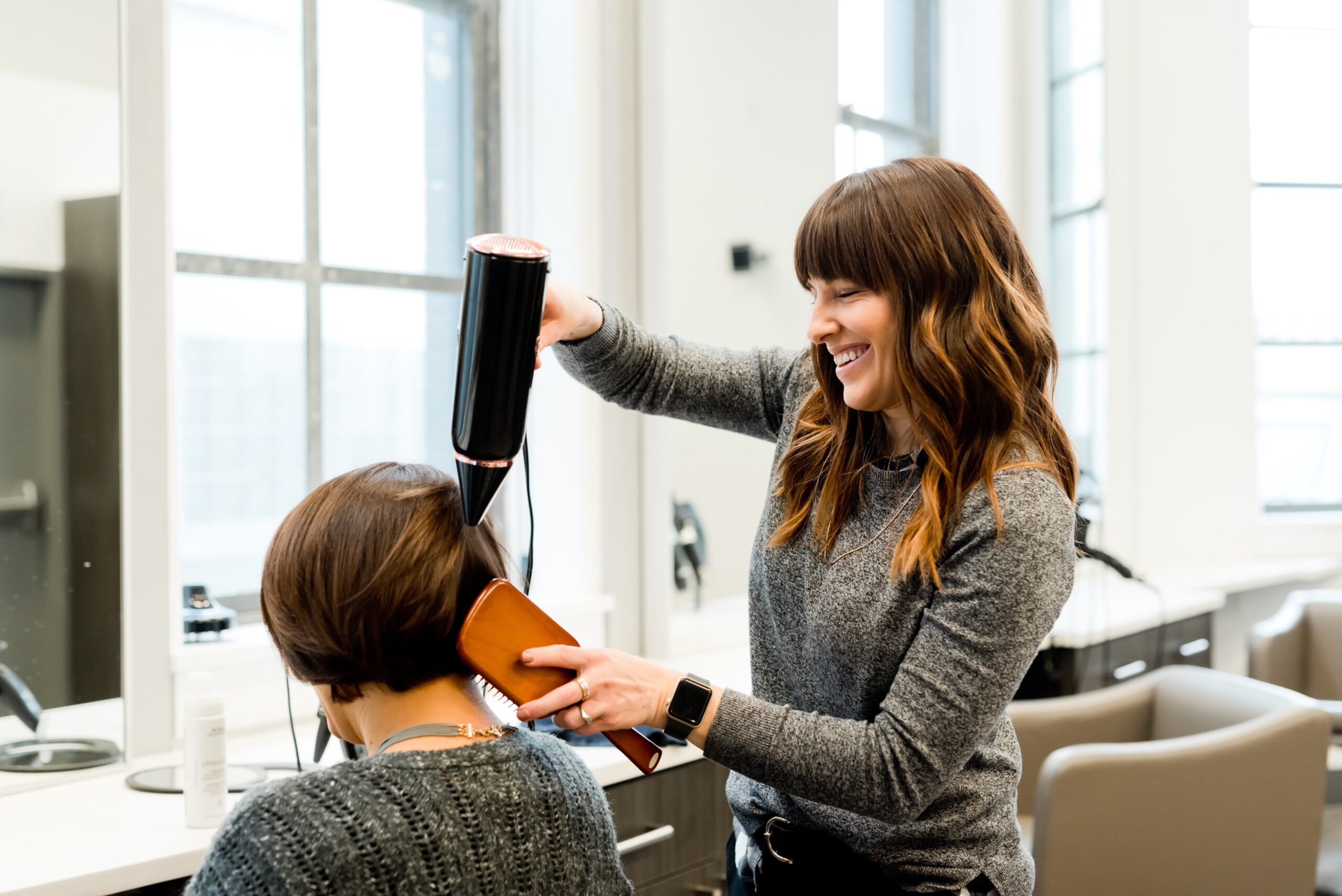 womann drying short hair in hair salon.