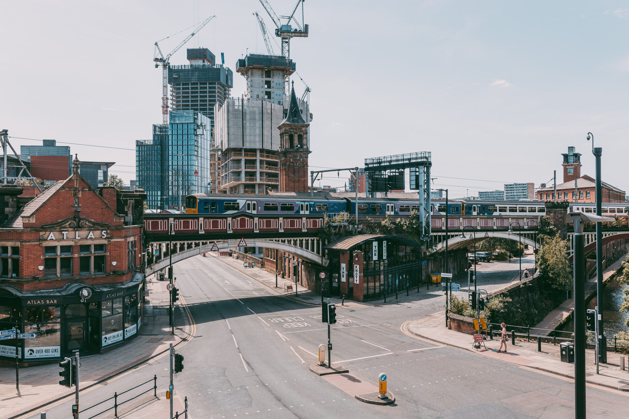 train bridge tall buildings and crane in Manchester.