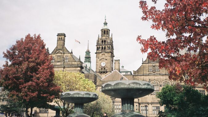 Sheffield town hall with fountains and trees in foreground.