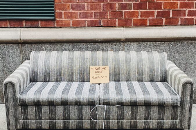 sofa for disposal sat in street.