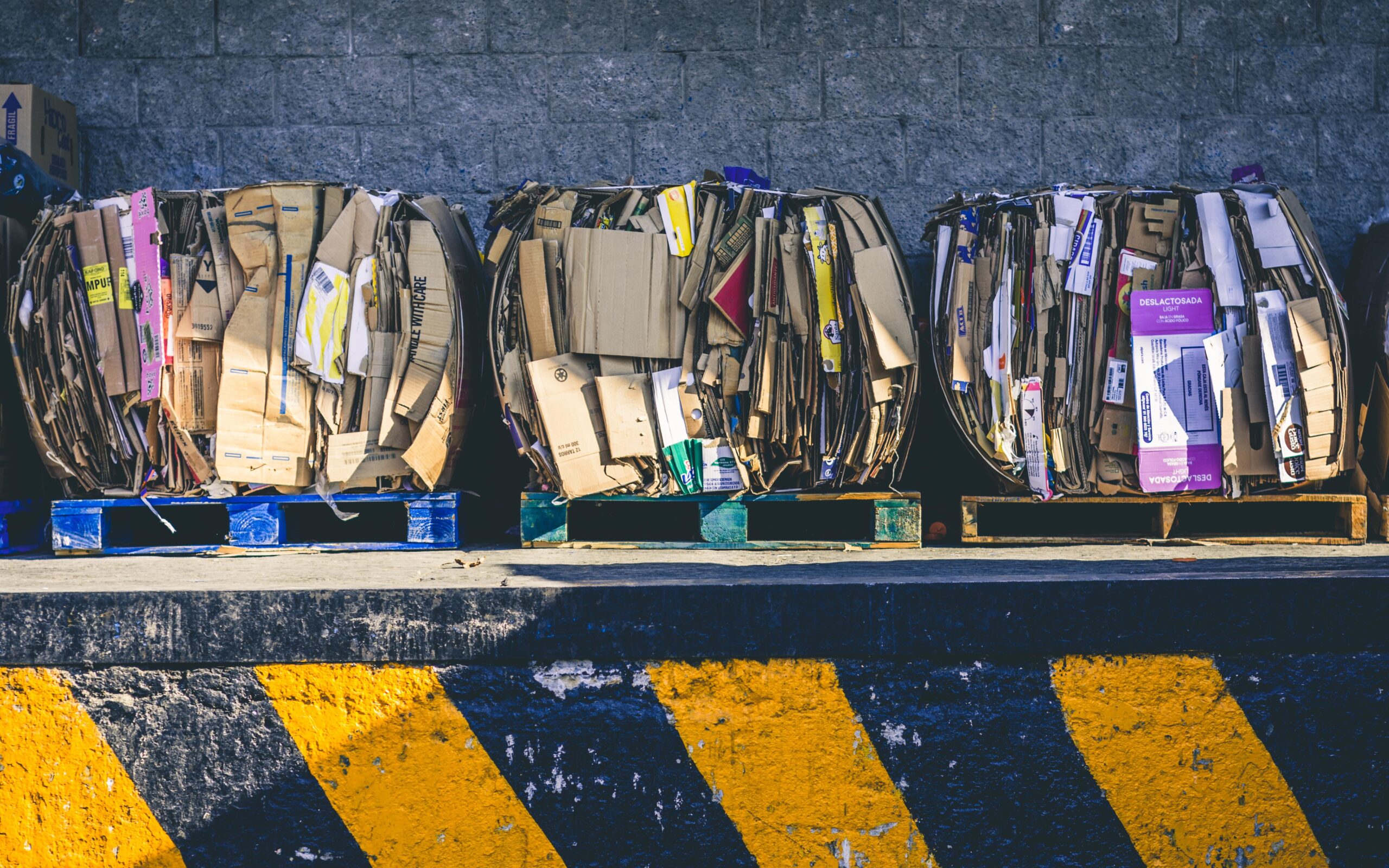 three bales of cardboard on pallets.