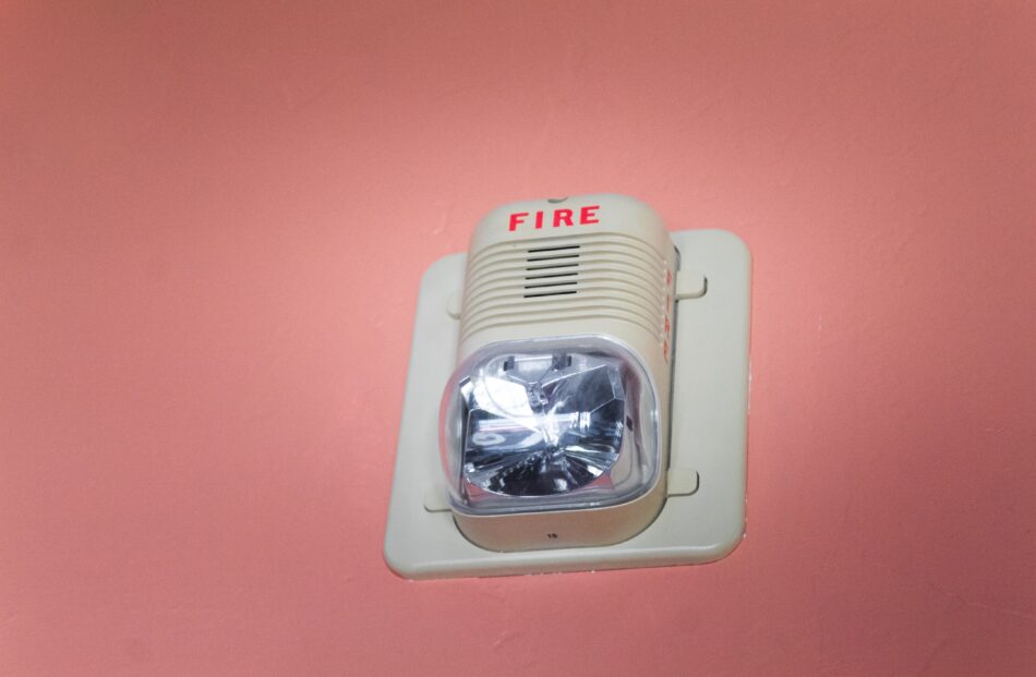 fire alarm on pink wall.