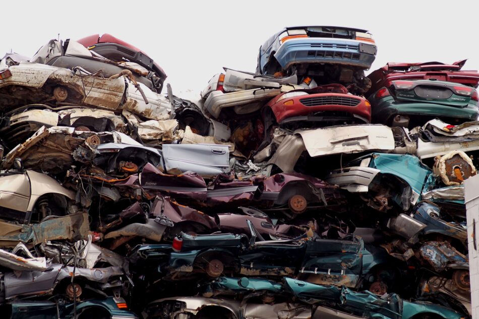 scrap cars piled up in junk yard.