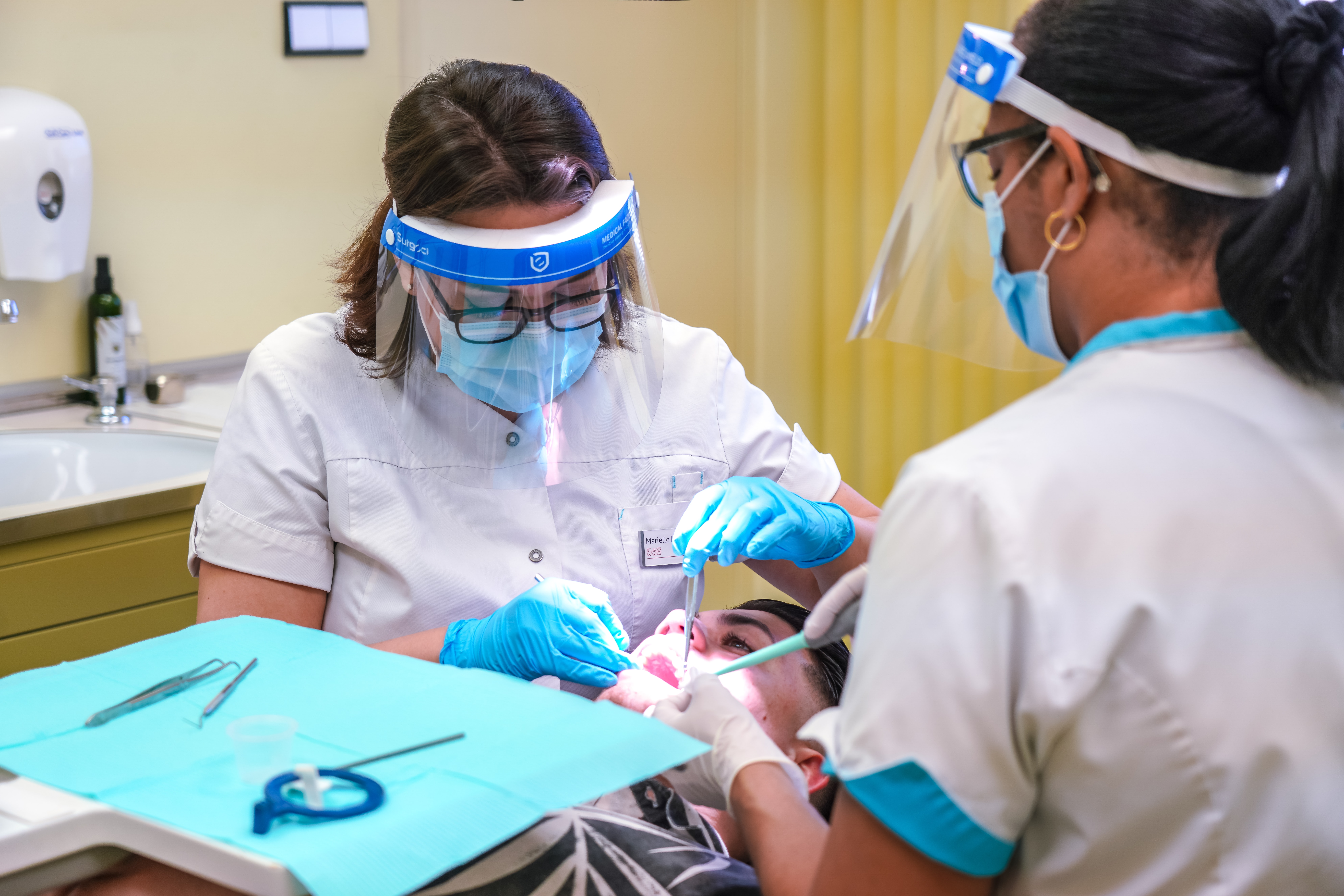 two dentists operating on patient.