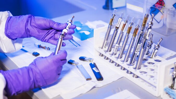 hands working with test tubes in laboratory.