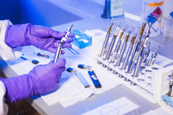 hands working with test tubes in laboratory.