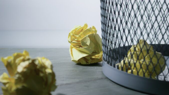 paper waste definition scrunched up paper in and next to waste bin.