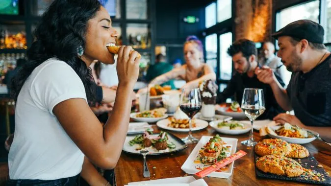 woman eating in restaurant with friends.