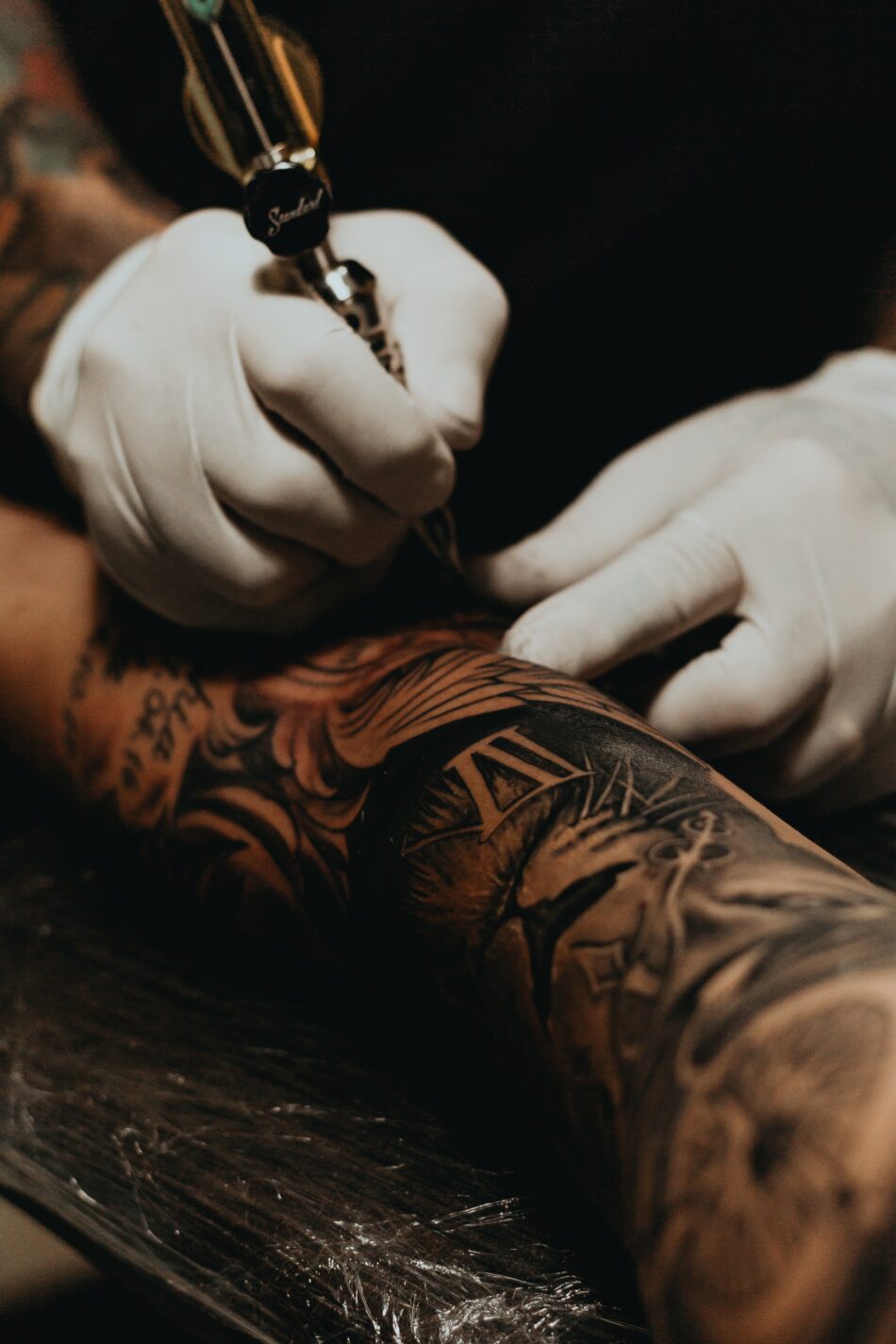 arm of man being tattoed.