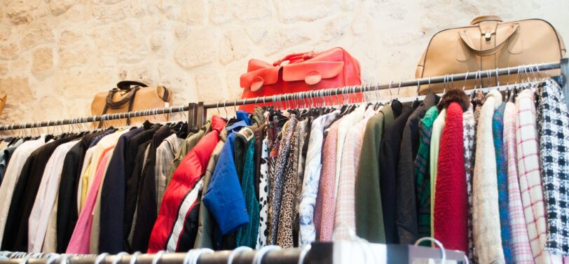 clothes on charity shop rail.