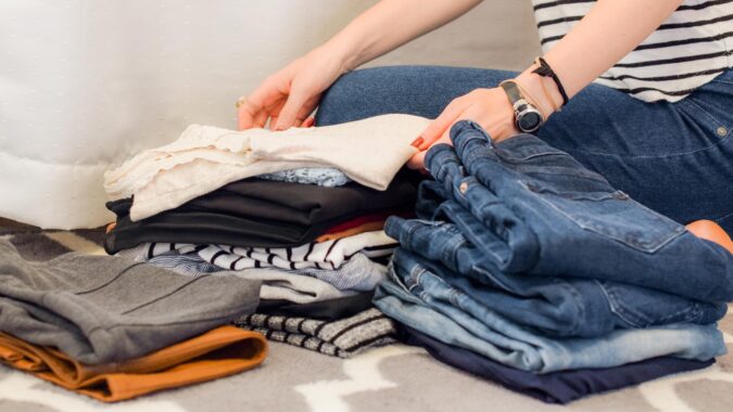 woman sorting clothes sat on the floor.