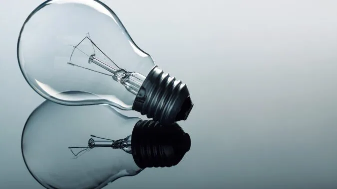 one light bulb on glass with reflection.