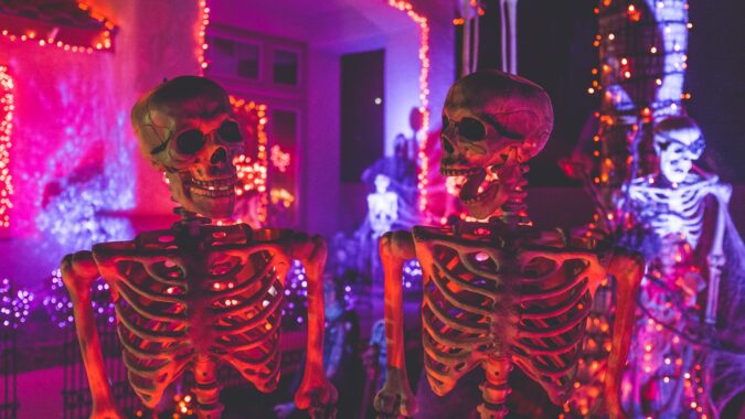 two plastic skeletons in Halloween house.