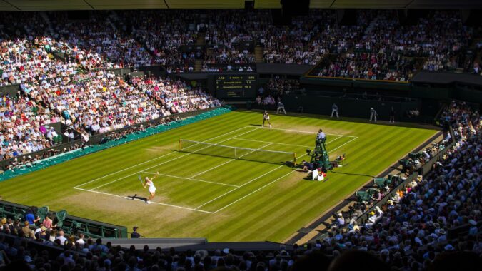 female tennis player serving at wimbledon centre court.