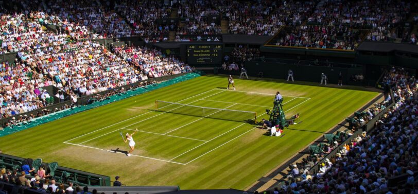 female tennis player serving at wimbledon centre court.