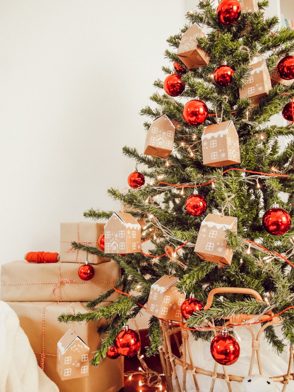 Chritmas tree with red baubles and cardboard house decorations.