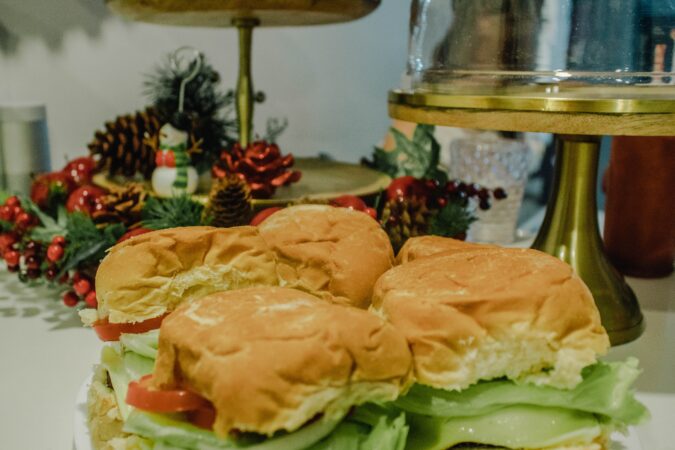 christmas sandwiches next to holly and snowman decoration.