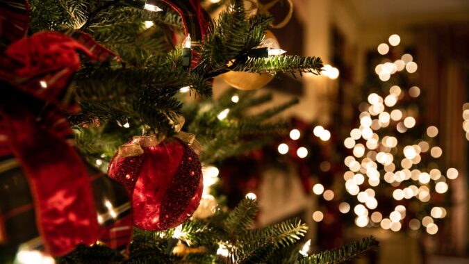 close up of Christmas tree lights and bauble on a tree.