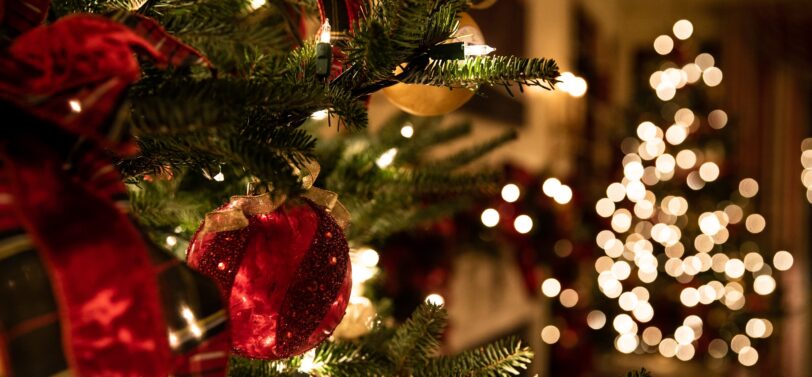 close up of Christmas tree lights and bauble on a tree.