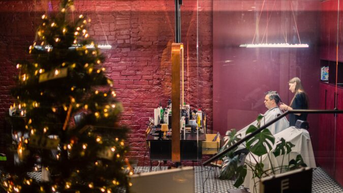 Christmas tree in hair salon with man having haircut.