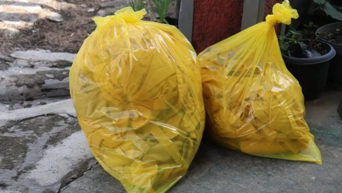 two yellow clinical waste bags full or rubbish.