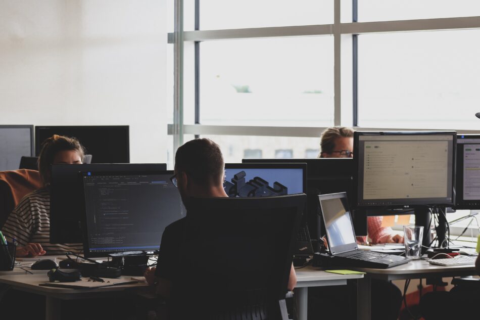 men working at computers in an office.