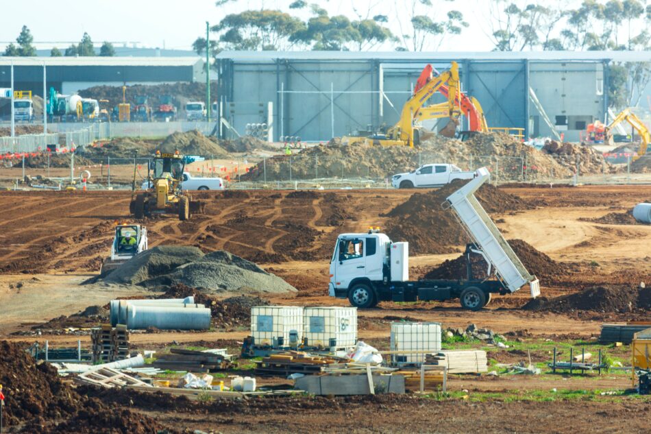 trucks and diggers working on construction site.