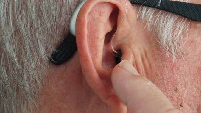 hearing aid in man's ear.