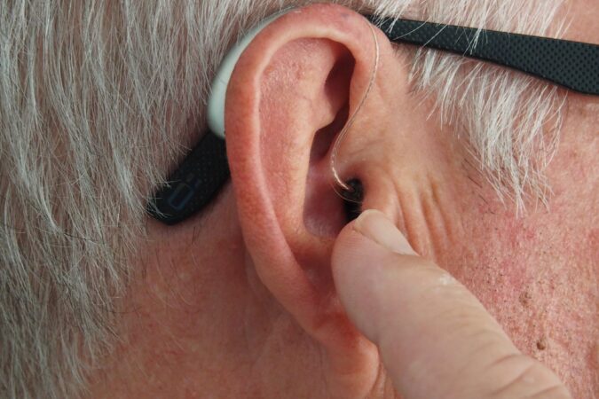 hearing aid in man's ear.
