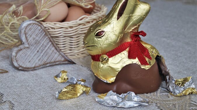 chocolate bunny with foil packaging half ripped off.