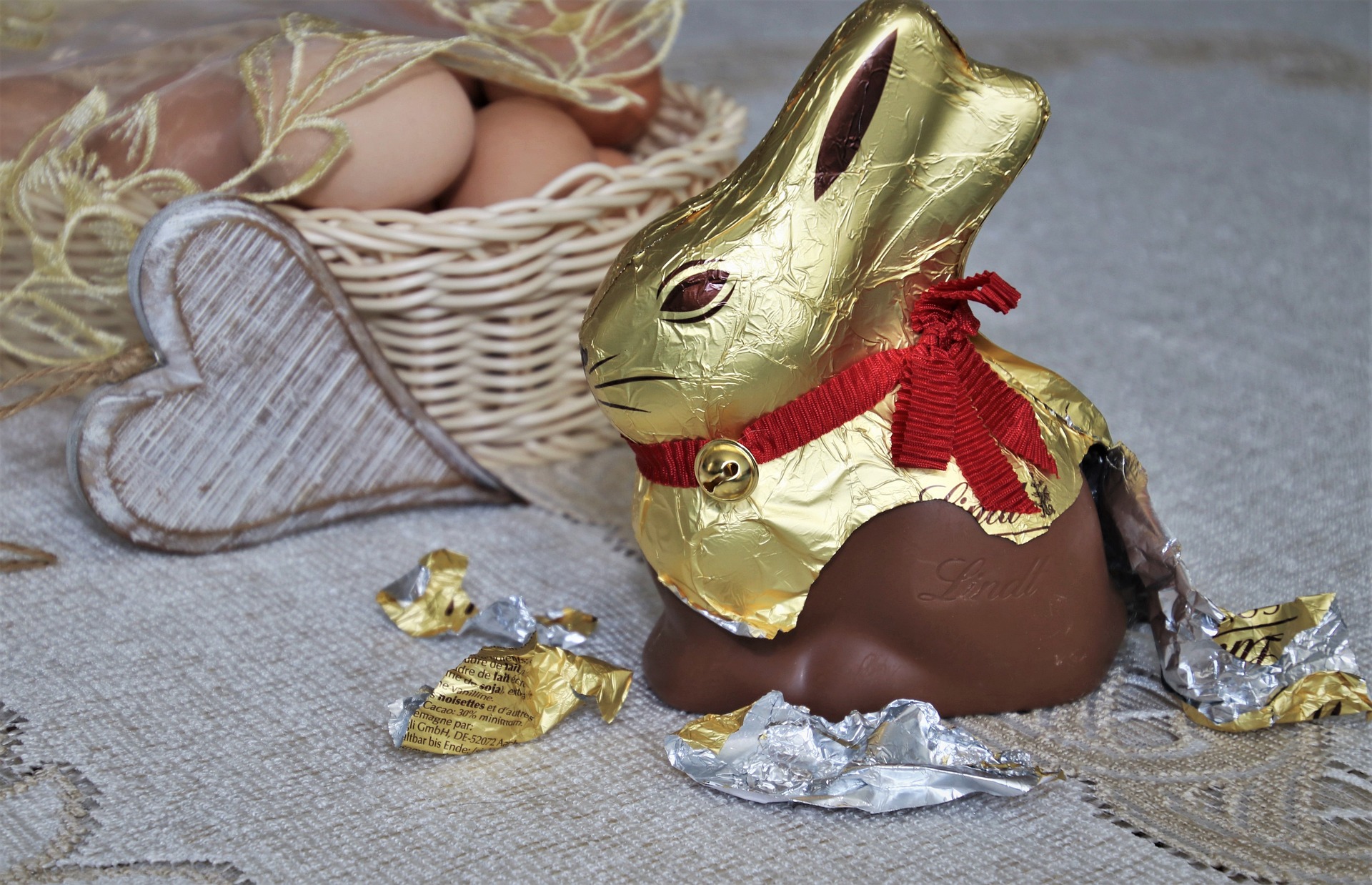 chocolate bunny with foil packaging half ripped off.