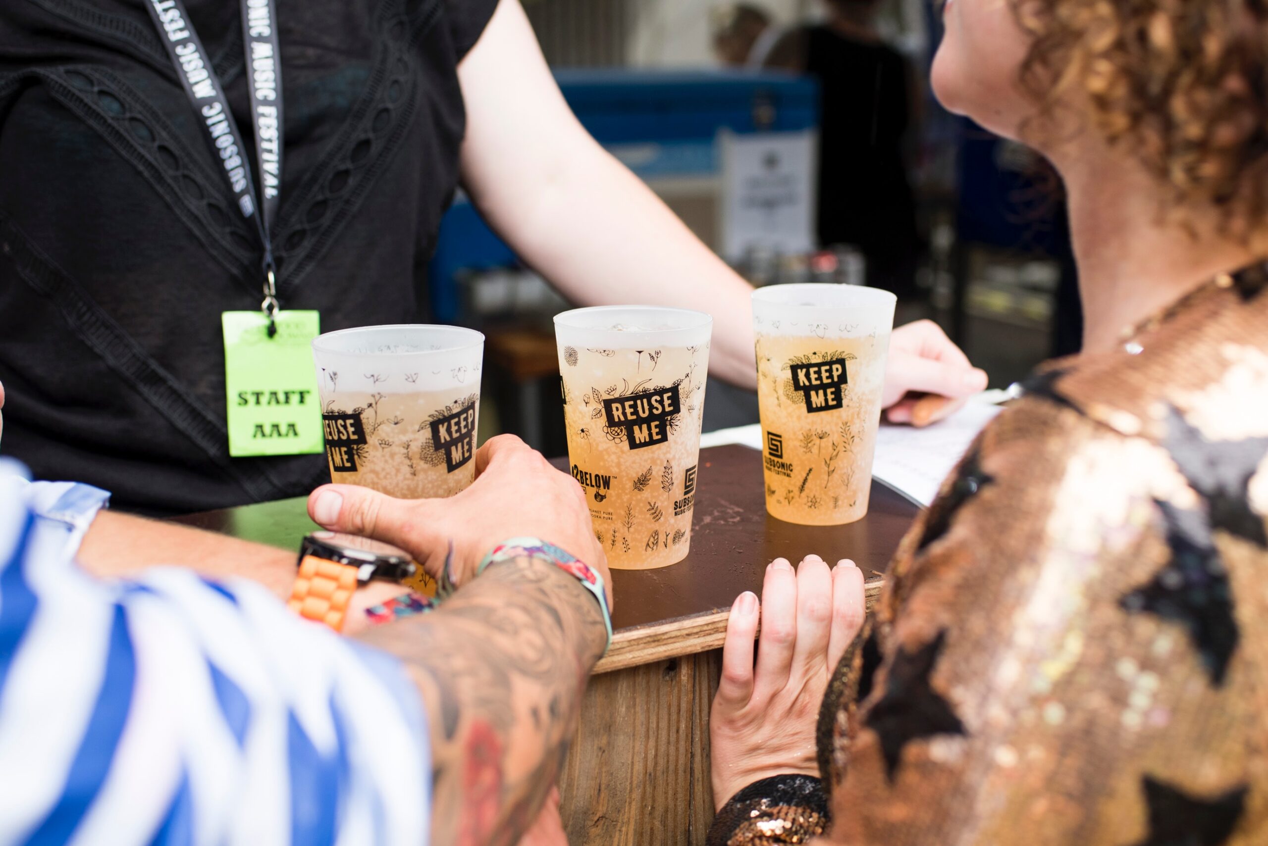 three reusable plastic cups full of beer at a festival.