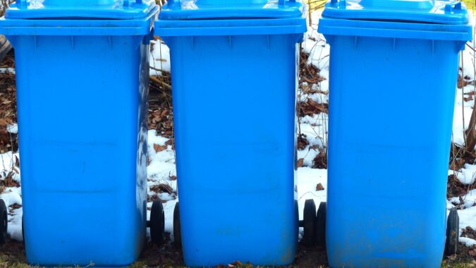 three wheelie bins in the snow.