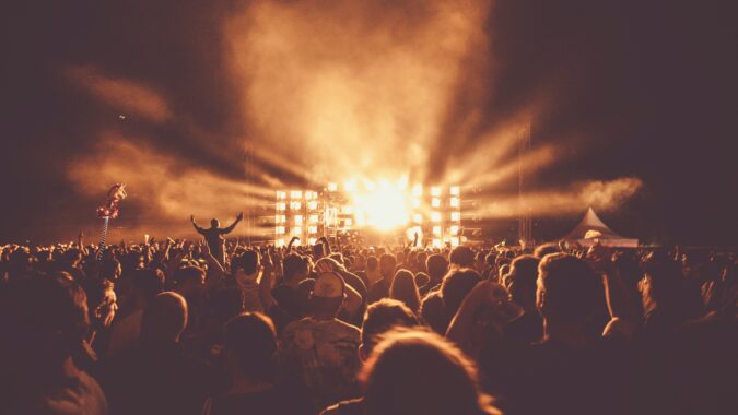 crowd at festival in front of stage at night.