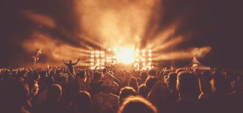 crowd at festival in front of stage at night.