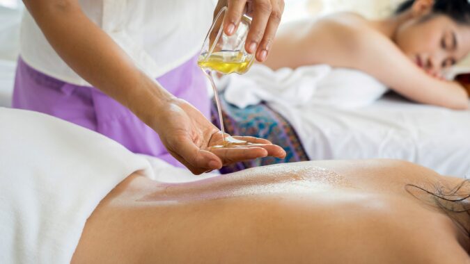 pouring oil onto hands before a massage.