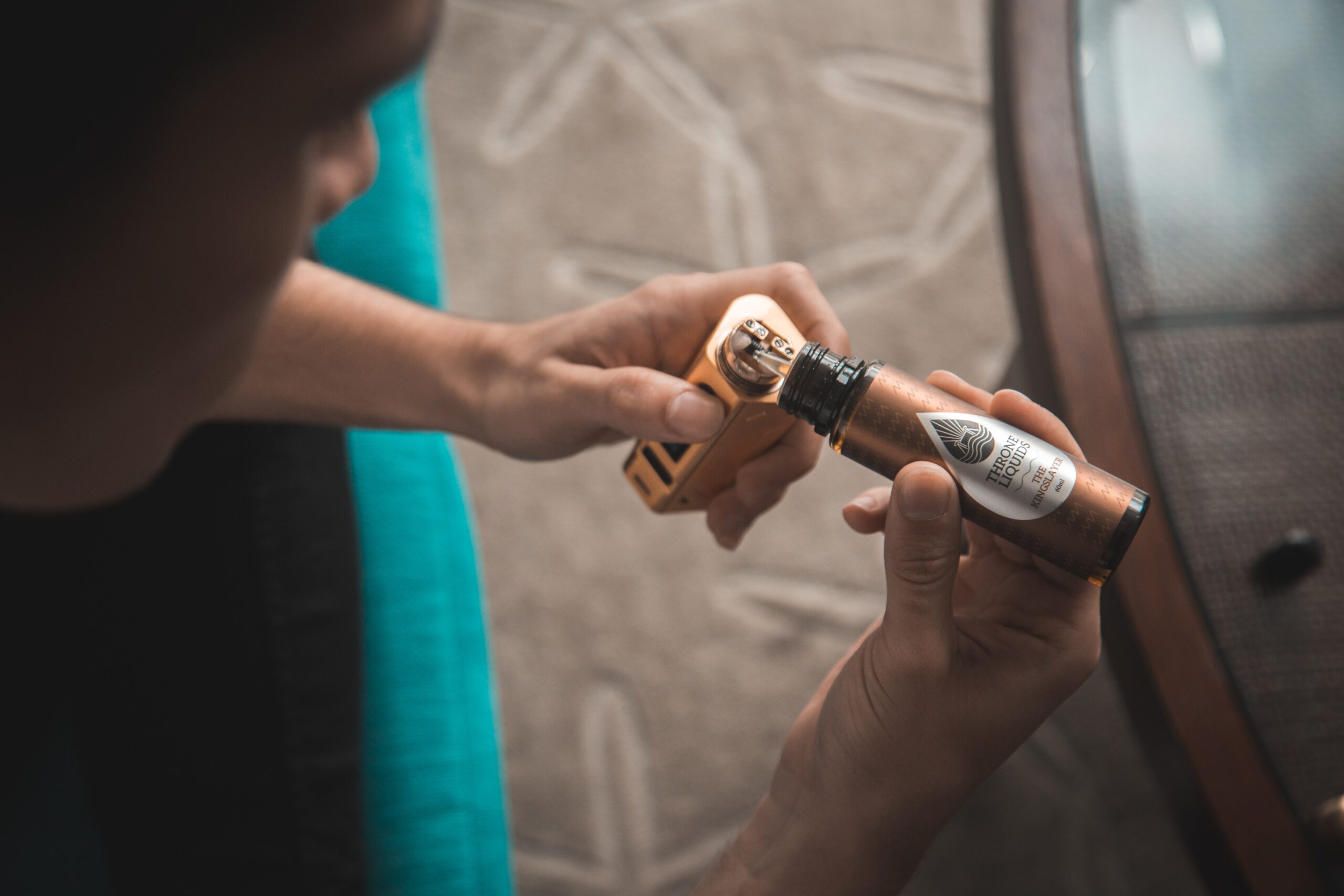 hands of person refilling a vape.
