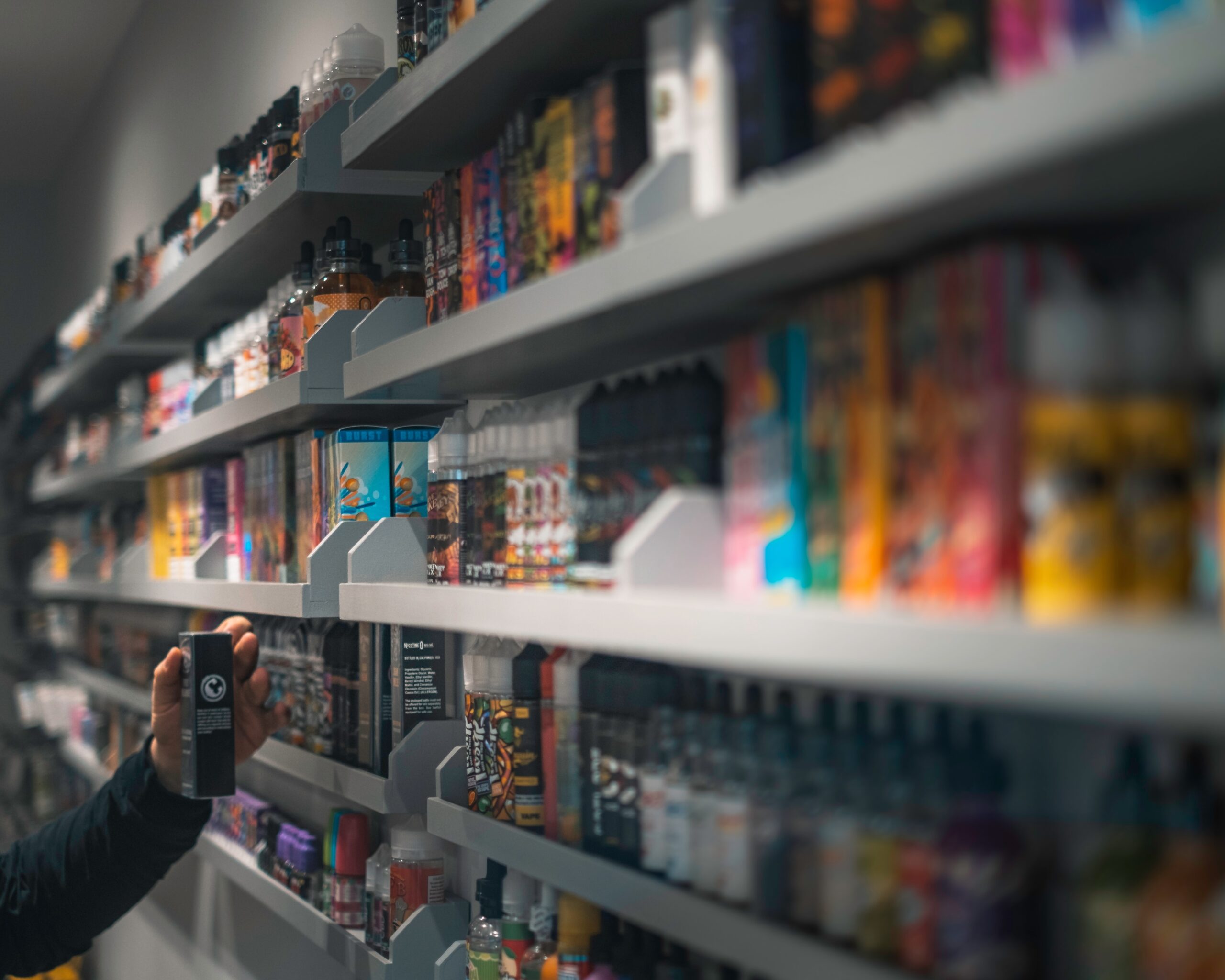 many boxes of vapes on a shelf in a shop.