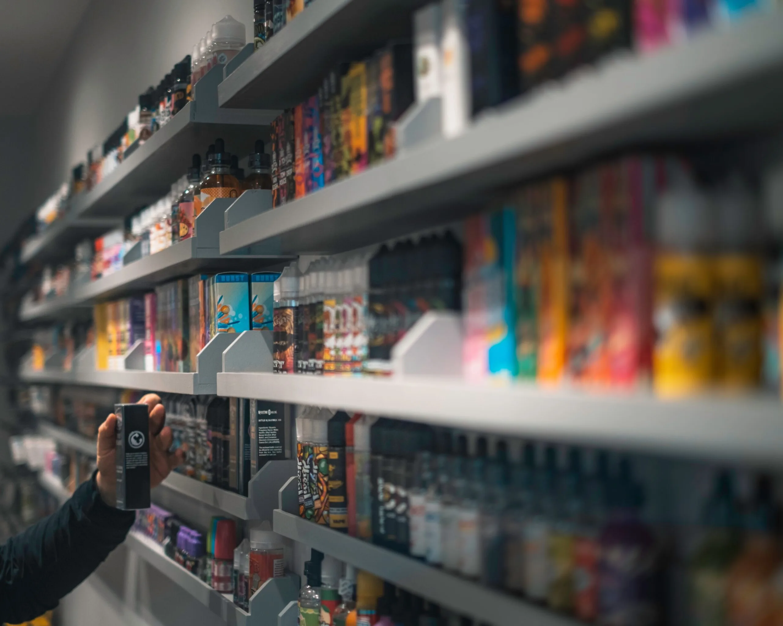 many boxes of vapes on a shelf in a shop.
