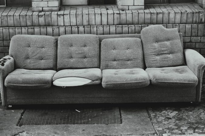 old grey four-seater sofa on the street.