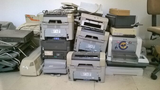 lots of old printers piled up.