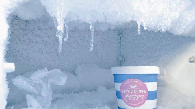 inside of a freezer with a tub of ice cream.