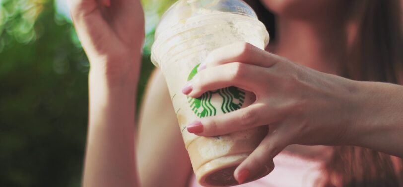 woman with Starbucks iced coffee in plastic cup and straw.