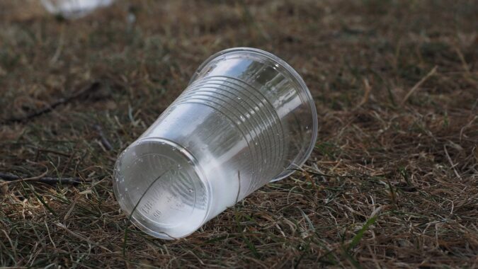 empty plastic cup on the floor in a field.