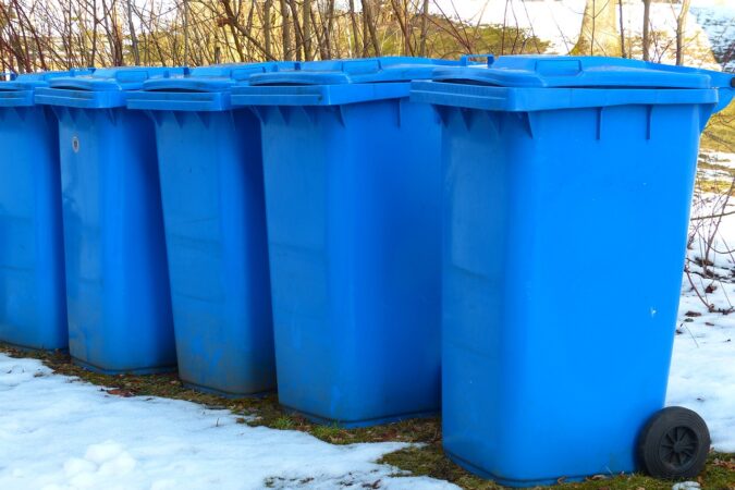 five wheelie bins in a row in the snow.