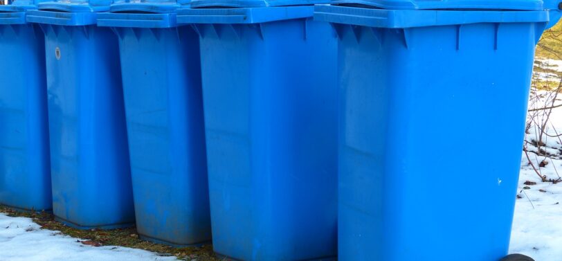 five wheelie bins in a row in the snow.