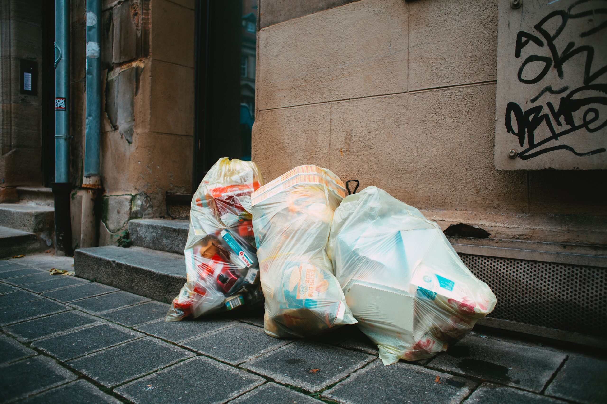 bags of rubbish containing controlled waste outside building steps.