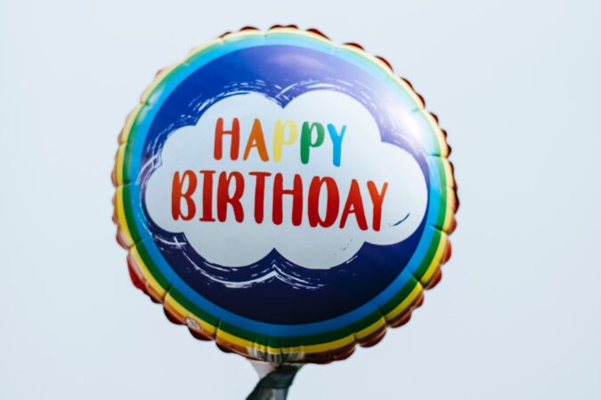 happy birthday balloon on a plastic balloon stick.